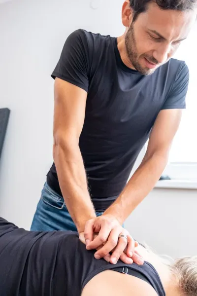Fisioterapista che tratta la schiena di una paziente con terapia manuale.