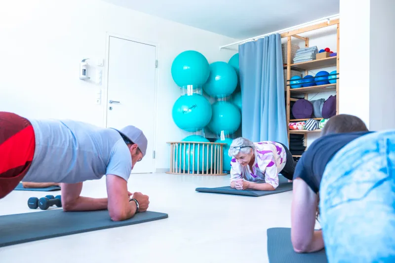 Participants training together in a forearm plank during a course at the therapy centre.